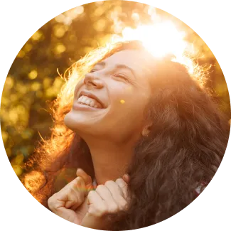 Woman with curly hair basking in sunlight, symbolizing joy and abundance